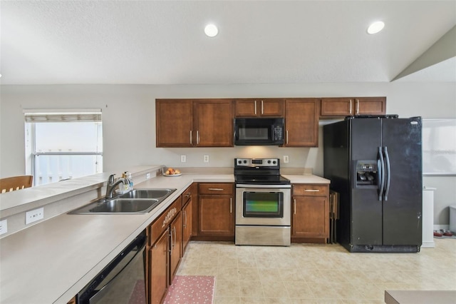 kitchen with sink, black appliances, and vaulted ceiling