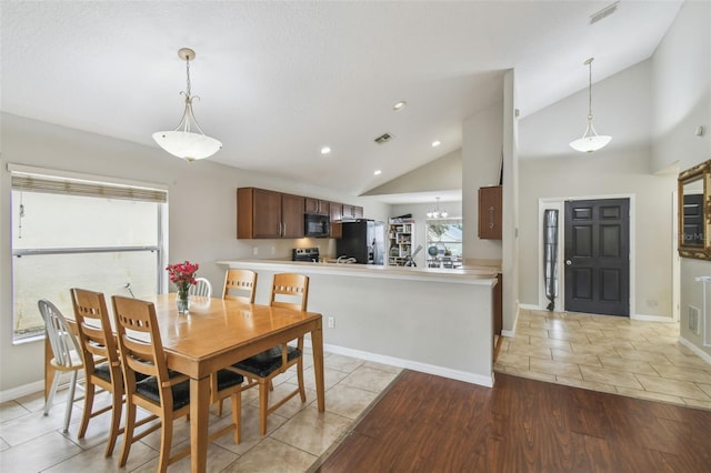 dining room with high vaulted ceiling and light tile patterned floors