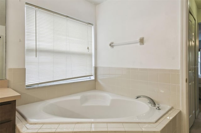 bathroom featuring tiled bath and vanity