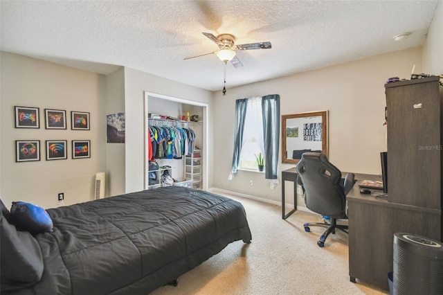 bedroom with a textured ceiling, a closet, light carpet, and ceiling fan