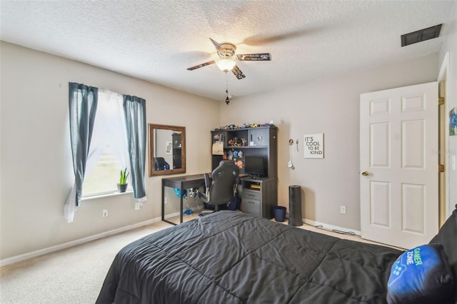 carpeted bedroom with ceiling fan and a textured ceiling