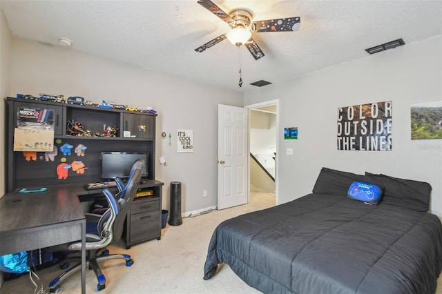 carpeted bedroom with a textured ceiling and ceiling fan