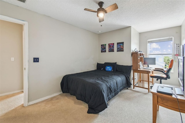 carpeted bedroom featuring ceiling fan and a textured ceiling