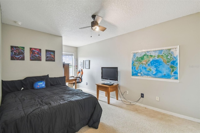 bedroom with ceiling fan, light carpet, and a textured ceiling