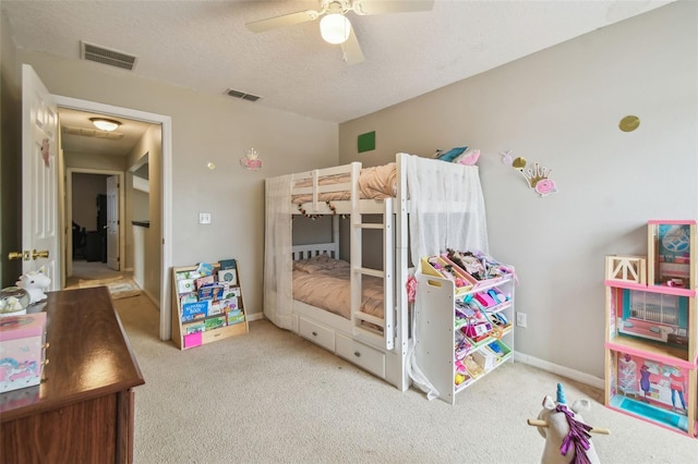 bedroom with ceiling fan, light colored carpet, and a textured ceiling