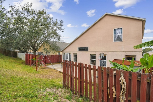 rear view of house featuring a lawn and a patio