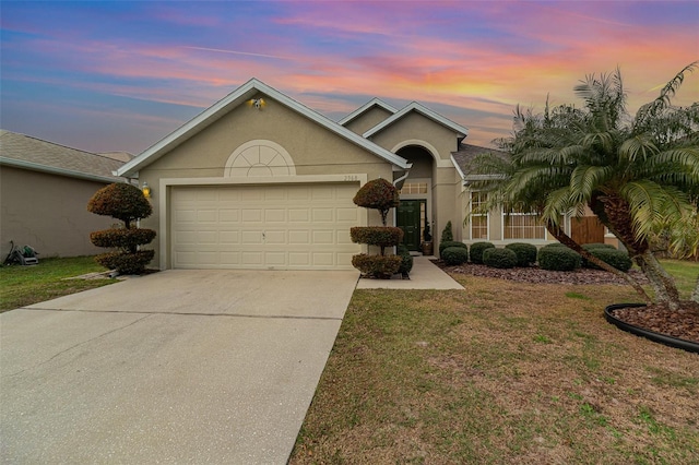 ranch-style home featuring a lawn and a garage