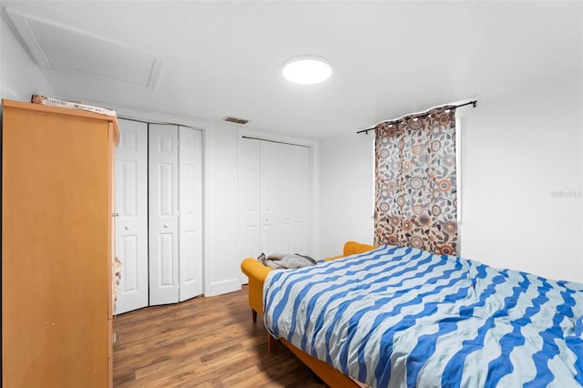 bedroom featuring hardwood / wood-style flooring and multiple closets