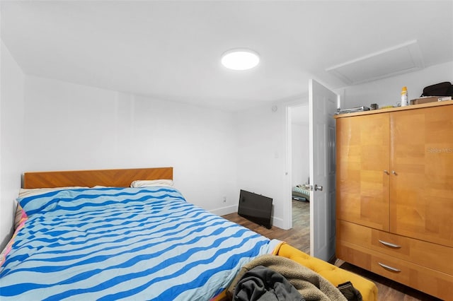 bedroom with dark hardwood / wood-style floors and a closet