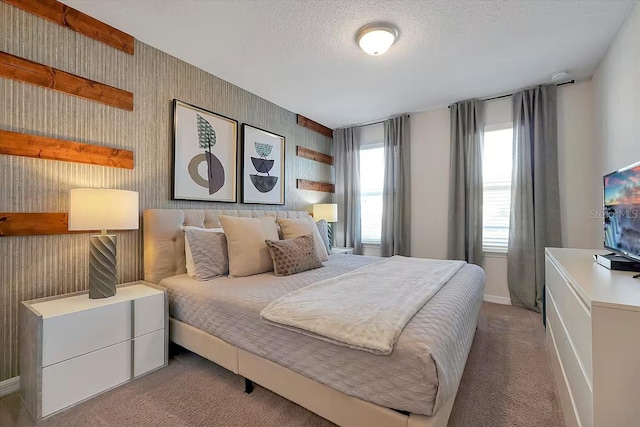 bedroom with a textured ceiling and light colored carpet