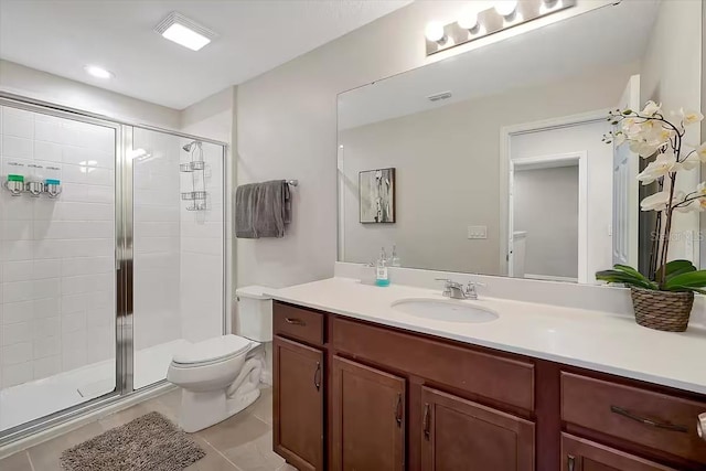 bathroom featuring tile patterned flooring, vanity, toilet, and a shower with shower door