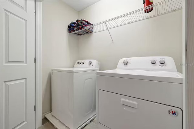 laundry area featuring washing machine and dryer and light tile patterned floors