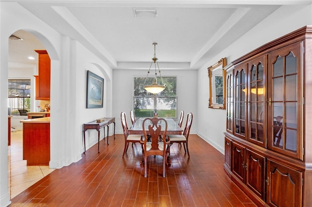 dining area with a tray ceiling and hardwood / wood-style flooring