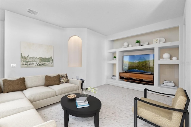 living room featuring built in shelves and light colored carpet