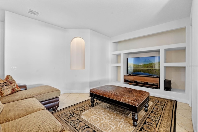 living room with built in shelves and light tile patterned floors