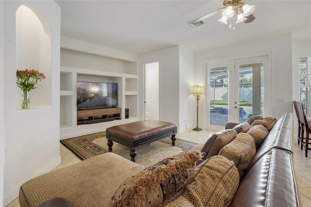 tiled living room with french doors, a textured ceiling, built in features, and ceiling fan