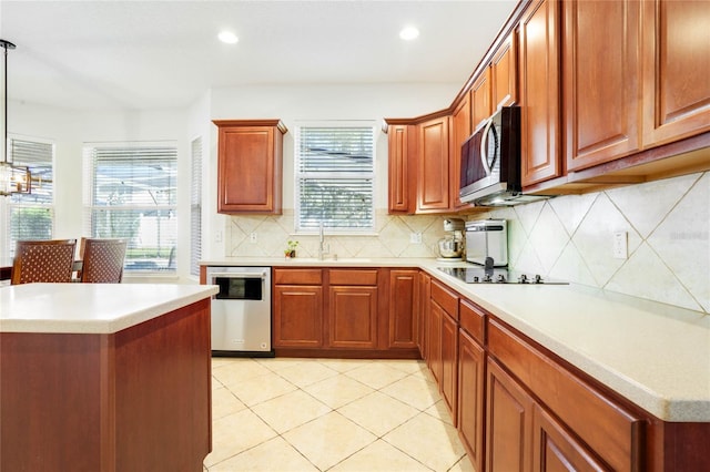 kitchen featuring decorative backsplash, appliances with stainless steel finishes, decorative light fixtures, and sink