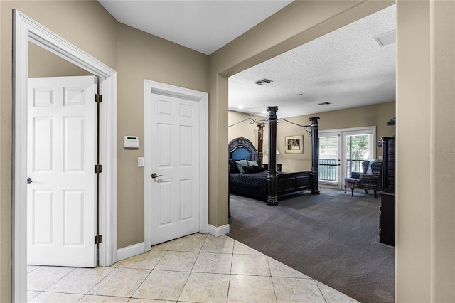 entrance foyer featuring a textured ceiling and light colored carpet