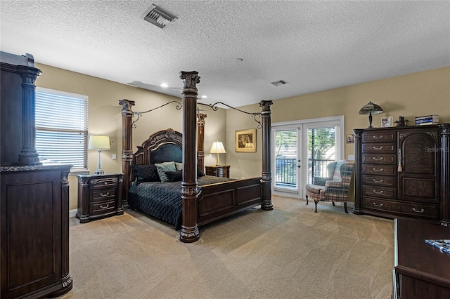 carpeted bedroom featuring access to outside, french doors, and a textured ceiling