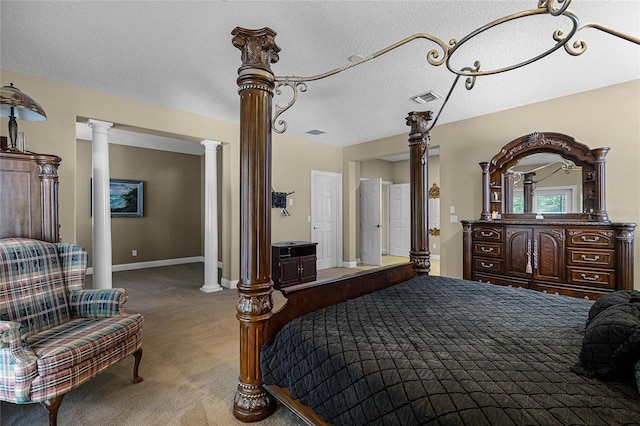 carpeted bedroom with ornate columns and a textured ceiling