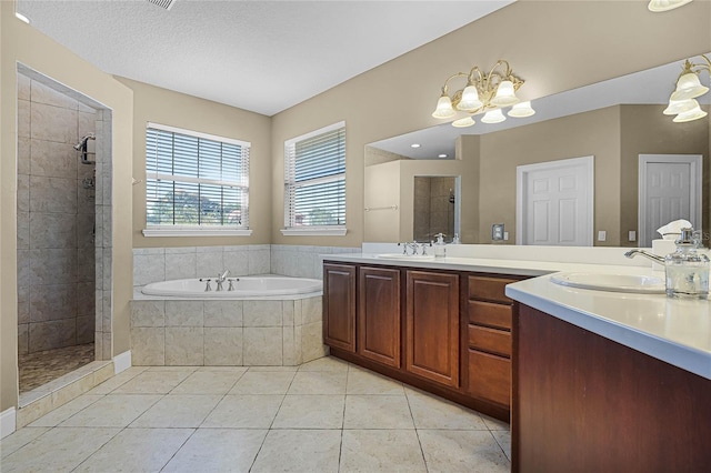 bathroom featuring tile patterned floors, vanity, shower with separate bathtub, and a notable chandelier