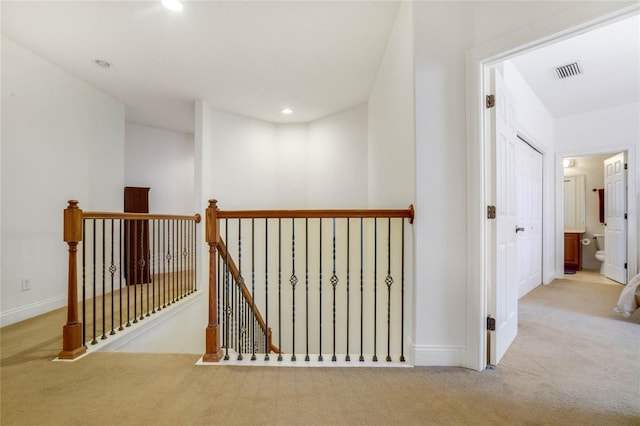 corridor featuring light colored carpet