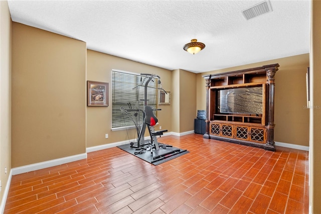 workout room with a textured ceiling and hardwood / wood-style flooring