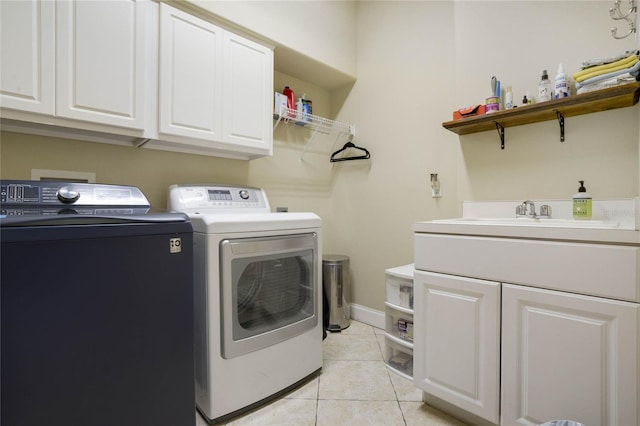 laundry area with washer and clothes dryer, light tile patterned flooring, cabinets, and sink