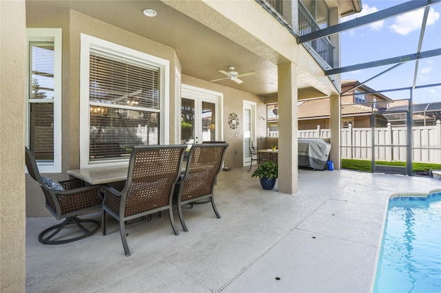 view of patio featuring french doors, ceiling fan, glass enclosure, grilling area, and a fenced in pool