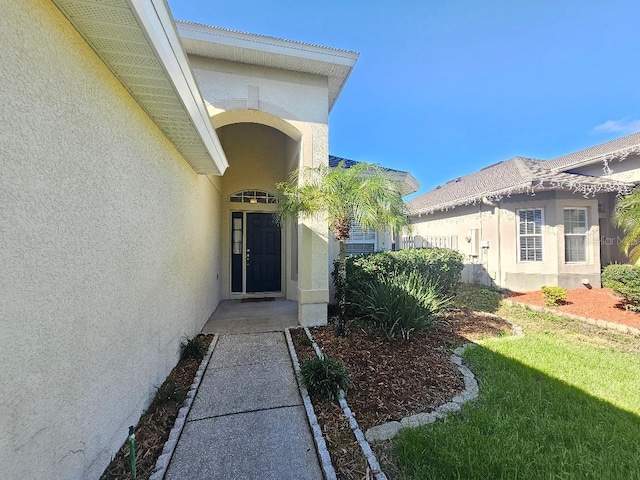 property entrance featuring a lawn