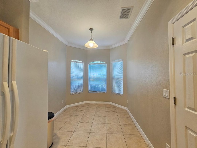 unfurnished dining area with light tile patterned floors and ornamental molding