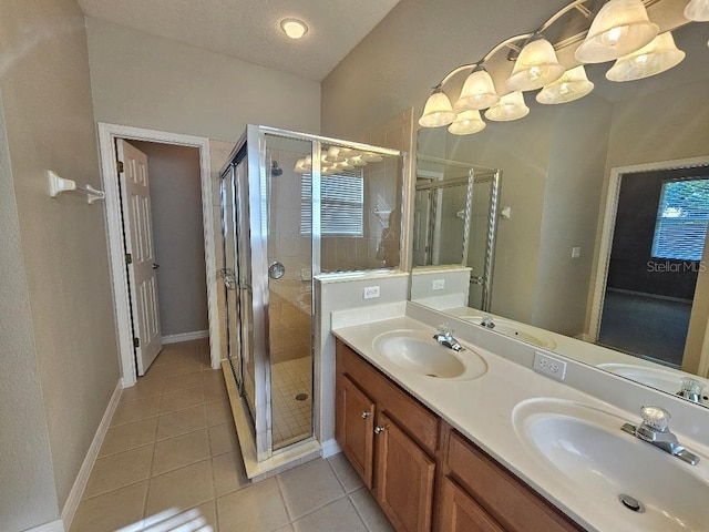 bathroom featuring vanity, a textured ceiling, tile patterned floors, and a shower with shower door