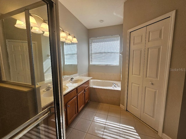 bathroom featuring vanity, tile patterned floors, and tiled tub