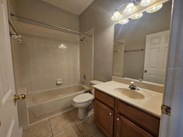 full bathroom featuring tile patterned flooring, vanity, tiled shower / bath combo, and toilet