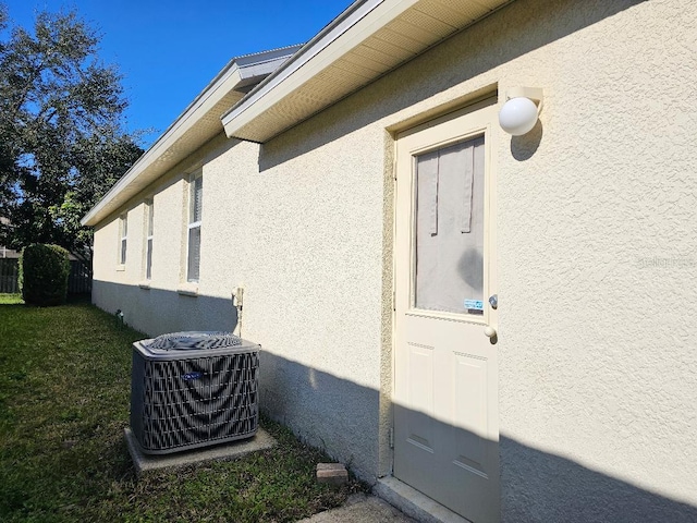 property entrance featuring a yard and central AC