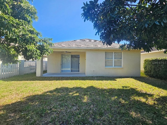 rear view of property with a lawn and a patio