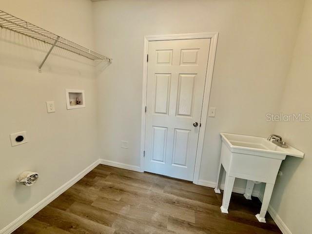 washroom featuring hardwood / wood-style flooring, washer hookup, and hookup for an electric dryer