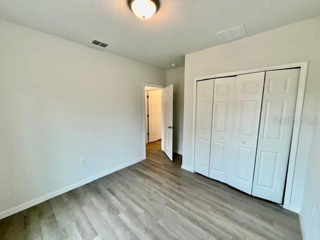 unfurnished bedroom featuring a closet and light hardwood / wood-style floors