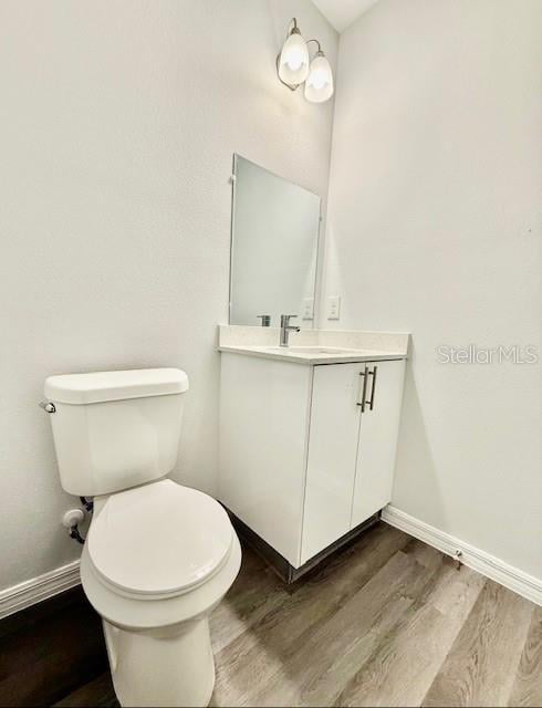 bathroom featuring hardwood / wood-style flooring, vanity, and toilet