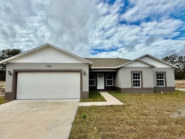 ranch-style home featuring a garage and a front lawn