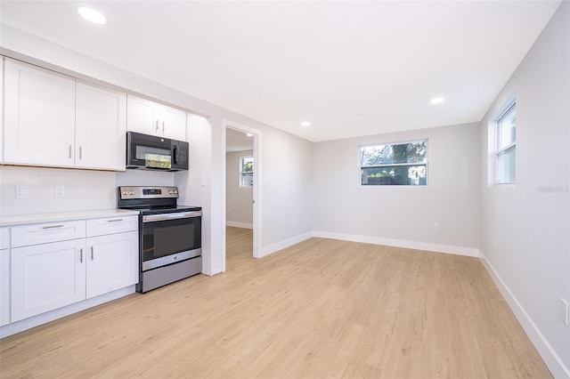 kitchen featuring electric stove, white cabinetry, and light wood-type flooring