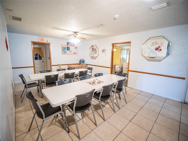 tiled dining room featuring a textured ceiling and ceiling fan