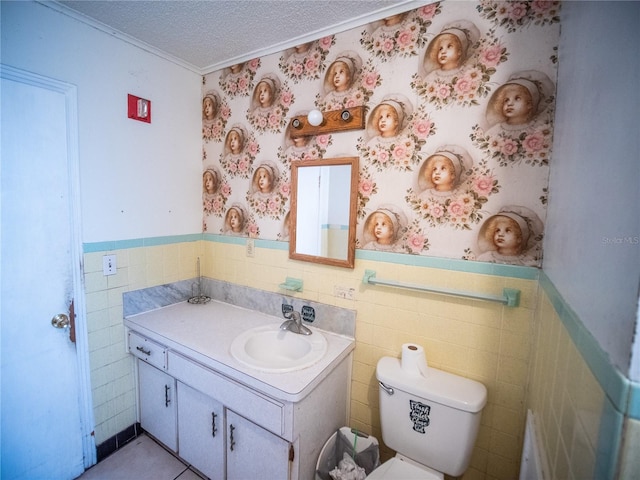 bathroom with vanity, a textured ceiling, crown molding, tile walls, and toilet