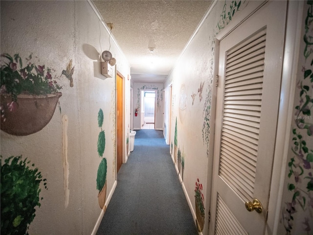 hallway with a textured ceiling, dark carpet, and crown molding