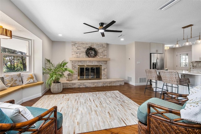 living room featuring hardwood / wood-style floors, plenty of natural light, and a fireplace