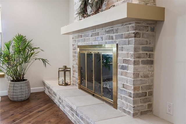 interior details featuring hardwood / wood-style floors and a brick fireplace