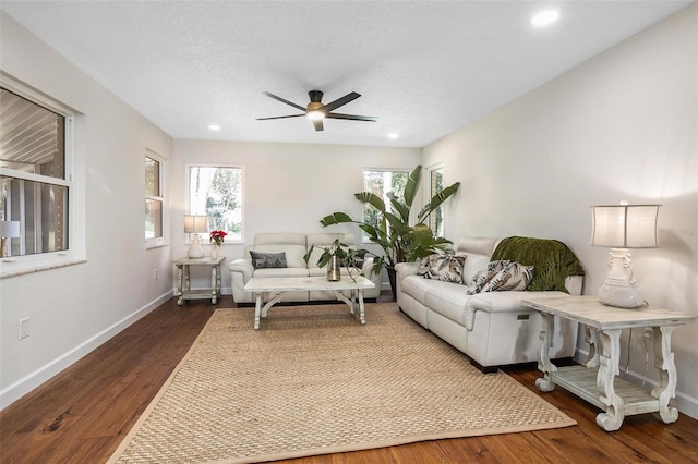 living room featuring a textured ceiling, dark hardwood / wood-style floors, and ceiling fan