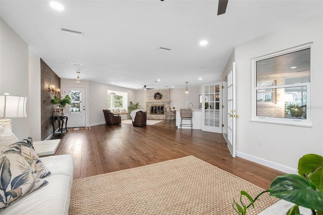 living room featuring dark hardwood / wood-style flooring, ceiling fan, a fireplace, and sink