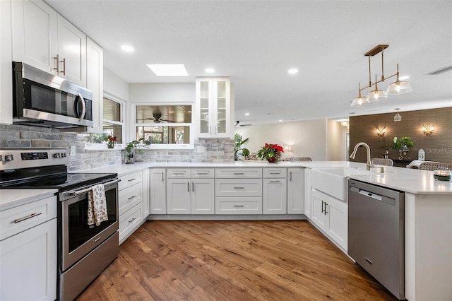 kitchen with kitchen peninsula, white cabinetry, and appliances with stainless steel finishes