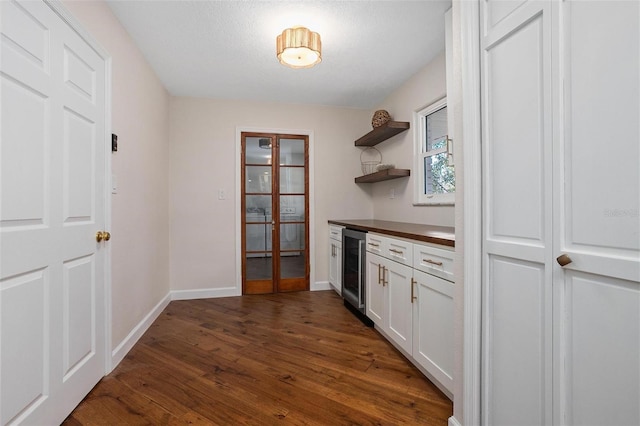 kitchen featuring white cabinetry, dark hardwood / wood-style flooring, beverage cooler, and french doors